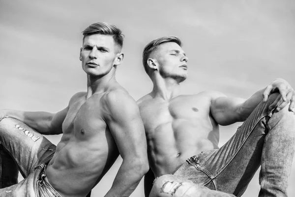 Men strong muscular athlete bodybuilder. Attractive muscular twins. Muscular healthy athletic body. Sexy torso attractive body. Masculinity concept. Men twins brothers muscular guys sky background
