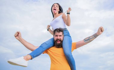 Onlar olması gerekiyordu. Sevgi dolu çift mutlu gülümseme eğleniyor. Sakallı adam sadece eğlenmek için kız arkadaşını piggydestek. Hipster seksi kadına bir piggyback yolculuğu veriyor. Bulutlu gökyüzünde aşık mutlu çift