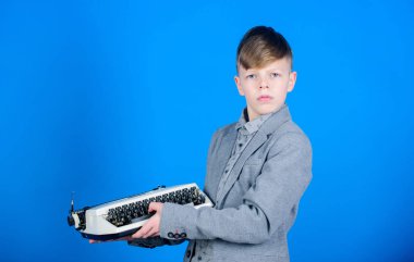 Vintage tipografi. Sevimli çocuk yazı makinesi var. Eski daktiloyu olan küçük bir çocuk. Akıllı çocuk kaynakcı Vintage makinesi kullanarak. Mavi arka planda Vintage daktilo tutan küçük çocuk