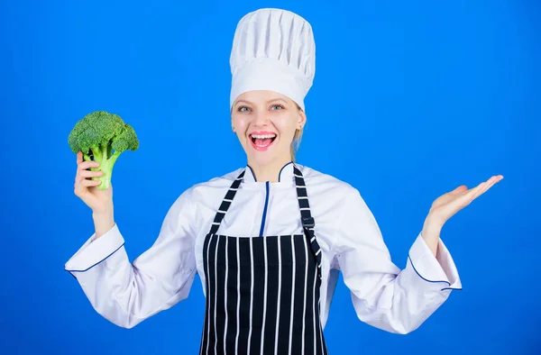 Schauen Sie mal. Profi-Koch lächelt mit Bio-Brokkoli und gestikuliert weg. glückliche Frau Werbung für Bio-Gemüse. Köchin mit Bio-Kohl. Bioprodukt präsentieren, Raum kopieren — Stockfoto