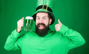 Irlandalı şansı seninle olabilir. Hipster Leprikon bira kupasını tutuyor. İrlandalı adam yeşil bira kadar başparmak gösteren. Saint Patricks gününü kutluyor. Aziz Patricks Günü için sakallı adam tost