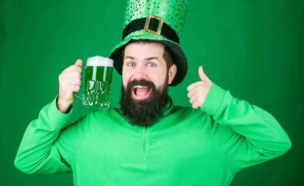 May the luck of the Irish be with you. Hipster leprechaun holding beer mug. Irish man showing thumbs up to green beer. Celebrating saint patricks day. Bearded man toasting to saint patricks day — Stock Photo, Image