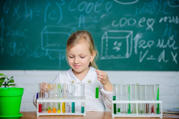 Educação escolar. Abordagem interessante para aprender. Futuro cientista. Explorar e investigar. Lição escolar. Menina bonito aluno da escola brincar com tubos de ensaio e líquidos coloridos. Experiência química escolar — Fotografia de Stock