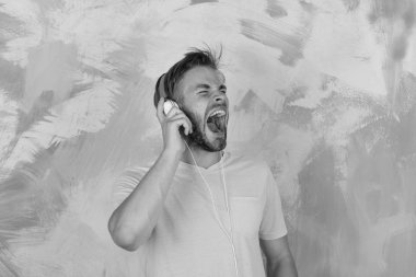 Akıllı telefonlu, mavi gözlü, şık hippi. Kulaklıklı, Amerikalı yakışıklı, sakallı adam. Müzikal yaşam tarzı. Neşeli genç DJ kulaklıkla şarkı dinliyor. Avrupalı adam eğleniyor.