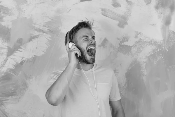 Blue eyed hipster elegante com smartphone. Bonito barbudo americano com auscultadores. Estilo de vida musical. Alegre dj adolescente ouvindo músicas através de fones de ouvido. homem europeu ter diversão tempo — Fotografia de Stock