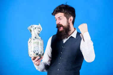 Dolar tasarrufları olan bir işadamı. Zenginlik ve refah. Güvenlik ve nakit para tasarrufu. Bankacılık konsepti. Genel tasarruf ipuçları. Adam sakallı hipster kavanoz dolu para. Finansal başarı