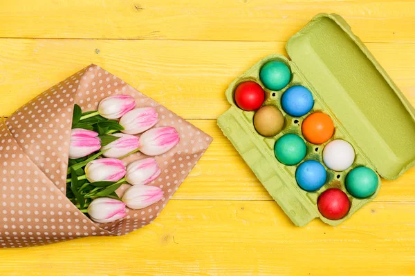 Yumurta avı. yumurta tepsisinde boyalı yumurta. Bahar tatili. Tatil kutlama, hazırlık. Lale çiçeği buketi. Sağlıklı ve mutlu bir tatil. Mutlu Paskalya. Paskalya geliyor — Stok fotoğraf