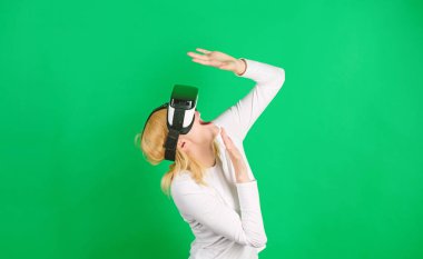 VR 'da siber eğlence deneyimi yaşayan bir kadın. Sanal gerçeklik deneyimi sırasında genç bir kadın havaya dokunuyor. Üç boyutlu cihaz teknolojisi deneyimi olan komik bir kadın. Yakın çekim. Sanal gerçeklik kadını.