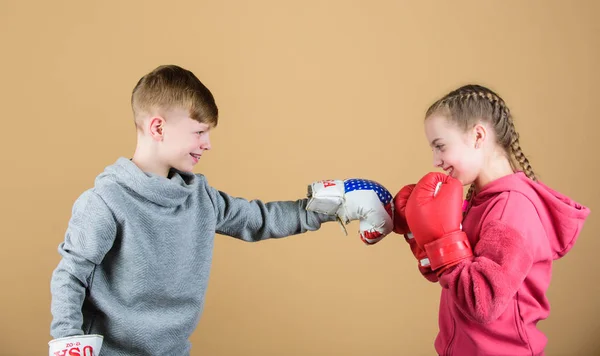 Batalla por atención. Atleta deportivo infantil practicando habilidades de boxeo. Boxeo deportivo. Los niños usan guantes de boxeo mientras luchan contra el fondo beige. Atacar y defender. Chica y chico boxeo competidores —  Fotos de Stock