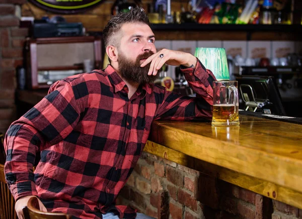 Hipster pihentető bár, sör. Rendelje meg az alkoholos italt! Bár pihentető helyen van, igyon és pihenjen. Az ember szakáll költ szabadidő sötét Bar. Brutális csípő szakállas férfi ül Bar Counter sört inni — Stock Fotó