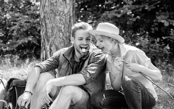 Par i kärlek camping skog äta rostade marshmallows. Rostning marshmallows populära gruppaktivitet runt brasan. Par äta rostade marshmallows mellanmål natur bakgrund. Camping aktivitet — Stockfoto