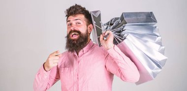 Satış ve indirim kavramı. İleriye dönük bir alışveriş satış sezonu üzerinde adam. Mutlu yüz hipster Alışverişkoliğin bağımlısı. Sakal ve bıyık taşır grup alışveriş torbaları, gri arka plan ile adam