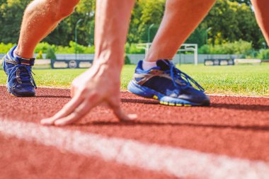 Starting point. Runner ready to go close up. Ready steady go concept. At the beginning of great sport career. Hand touch track path close up. Hand of sportsman on running track low start position clipart