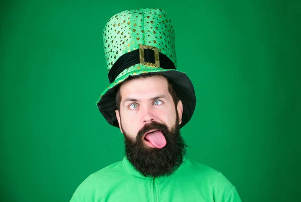 Going crazy on saint patricks day. Irish man with beard grimacing in green. Bearded man celebrating saint patricks day. Hipster in leprechaun hat and costume