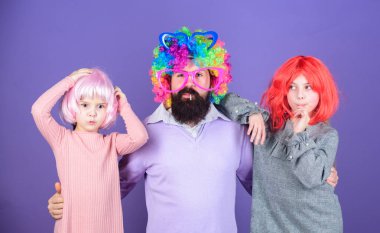 Baban ne kadar çılgın. Sakallı adam baba ve çocuklar kızlar renkli peruğu Menekşe arka plan giyerler. Dostu aile giyim parti aksesuarları. Şimdiye kadar en iyi baba. Babası kucaklama kız. Sadece eğlence için. Parti zamanı