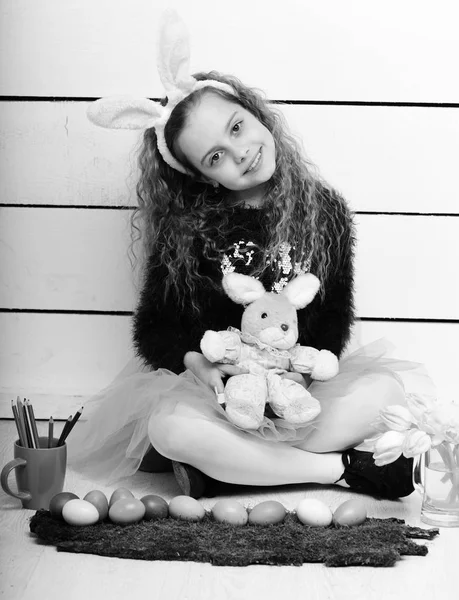 Menina feliz com brinquedo de coelho de Páscoa, lápis, flores de tulipa, ovos — Fotografia de Stock
