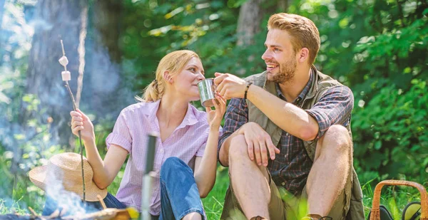 Weekend picnic. Food for hike and camping. Couple sit near bonfire eat snacks and drink. Couple take break to eat nature background. Couple in love camping forest hike. Hike snacks and beverages