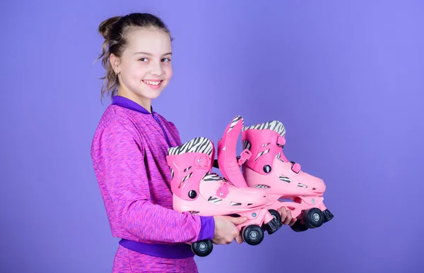 Hobby y ocio activo. Feliz infancia. Elige el tamaño adecuado de los patines. A los niños les encantan los patines. Patina a todas las chicas que sueñan. Vamos a montar. Niña linda niño sostiene patines —  Fotos de Stock