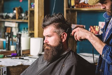 Kuaför saç kesme makinesi ile saç modeli sakallı, berber arka plan için çalışır. Styling saç tarak ve kesme makinesi ile sakallı istemcisinin berber. Saç kesimi kavramı. Hipster istemci Başlarken saç kesimi