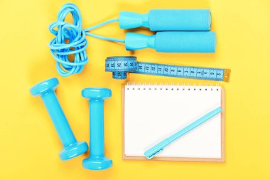 Kilo kaybı ve aktif yaşam tarzı kavramı. Blocknote, kalem dumbbells ile