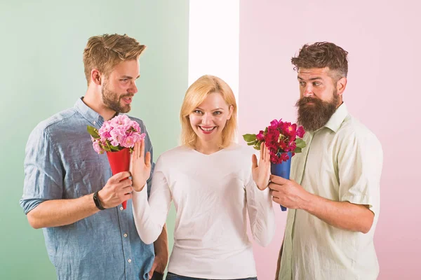 Men competitors with bouquets flowers try conquer girl. Girl smiling reject gifts. Feminism concept. Woman smiling reject both male partners. Out of relations. Girl popular receive lot men attention — Stock Photo, Image