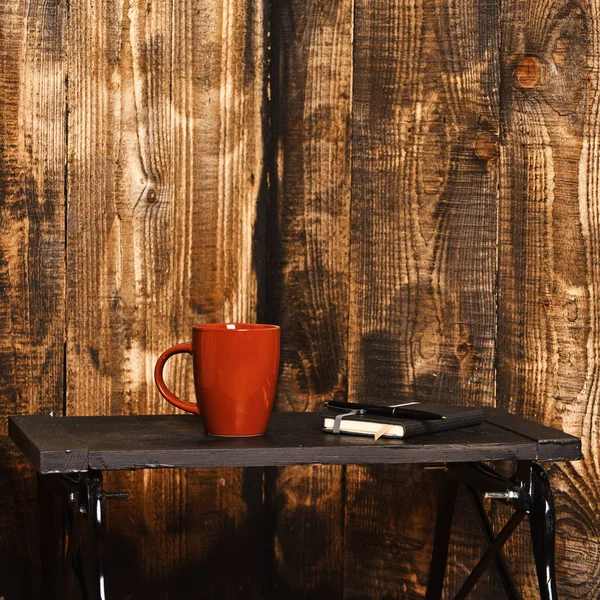 Hot drink and book with bookmark on low table. — Stock Photo, Image