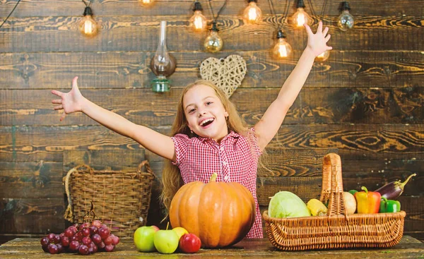 Kid girl fresh vegetables harvest rustic style. Fall harvest holiday. Child presenting harvest vegetable garden wooden background. Elementary school fall festival idea. Celebrate harvest festival