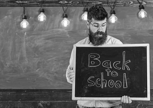 学校のコンセプトです。黒板の文を書かれた学校にこらえて眼鏡の教師。ひげと口ひげ驚いた顔歓迎学生の背景に黒板を持つ男 — ストック写真