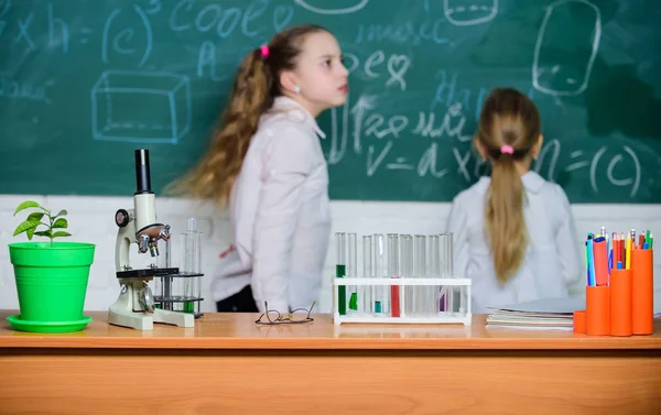 Microscope and test tubes on table in classroom. Kid near school chalkboard background defocused. School biology lesson. Kid study biology with equipment in school. Knowledge day. Biology concept — Stock Photo, Image