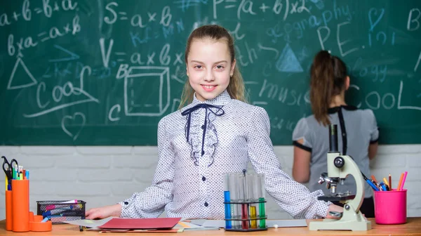 Le ragazze studiano chimica a scuola. Reazioni chimiche delle provette al microscopio. Pupille alla lavagna. Affascinante scienza. Scuola di educazione formale. Sperimentazione educativa. Torniamo a scuola. Classi scolastiche — Foto Stock