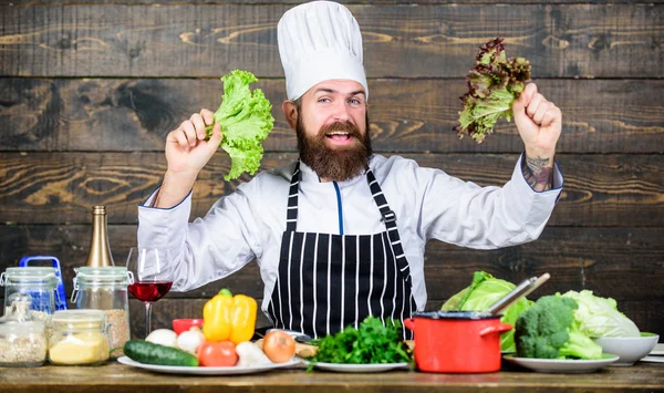 Gesund ernähren. Diätkonzept. Mann trägt Hut und Schürze mit Kopfsalat. gesunde Ernährung. Bärtige Hipster-Profiköche halten Salatgrün in der Hand. gesunde vegetarische Rezepte. Rezept für gesunde Ernährung — Stockfoto