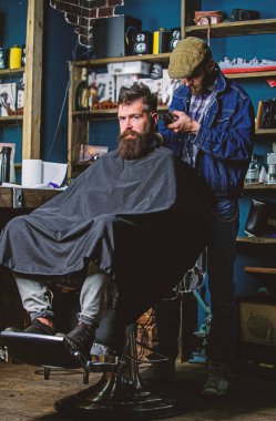 İstemci ense üzerinde kırpma makası kesme saçlı berber. Hipster istemci Başlarken saç kesimi. Hippi saç modeli kavramı. Sakallı adam berber arka plan saçına Kuaför saç kesme makinesi ile çalışır