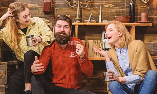 Freunde haben Spaß, reden und trinken im Holzinterieur. Männer und Frauen mit glücklichen Gesichtern diskutieren und trinken. Freunde bei Tee oder Wein im Wohnzimmer lachen und Spaß haben. Kommunikationskonzept — Stockfoto