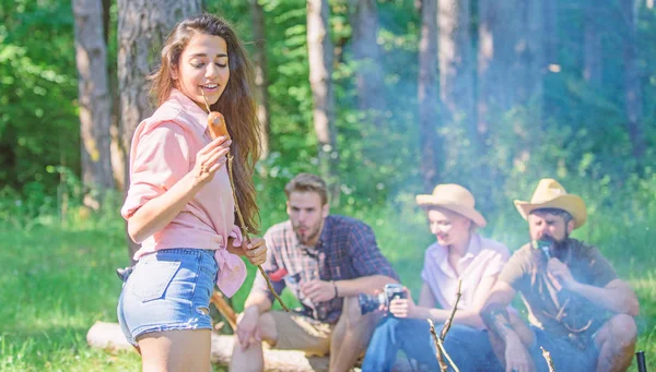 Weekend hike. Picnic with friends in forest near bonfire. Company having hike picnic nature background. Tourists with camera relaxing checking photos. Hikers sharing impression of walk and eating