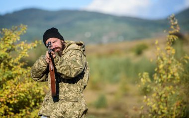 Adam acımasız hakem doğa arka plan. Avcı tutun tüfek. Sakallı avcı boş zaman avcılık harcamak. Odaklanma ve konsantrasyon deneyimli avcı. Avcılık düzenlenmesi. Avcılık erkeksi hobi kavramı