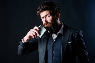 Akşamdan kalma. Uzun çalışma günü. Takım elbiseli bir iş adamı. acımasız beyaz hipster kötü bağımlılığı var. Sakallı olgun hipster şişesi cebine koydu. Lisans ve tek. Sakallı adam içki alkol