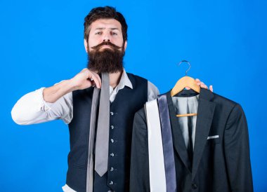 How about this tie. Brutal hipster holding colorful tie collection and suit jacket. Bearded man matching neck tie color to formal coat. Choosing a perfect tie clipart