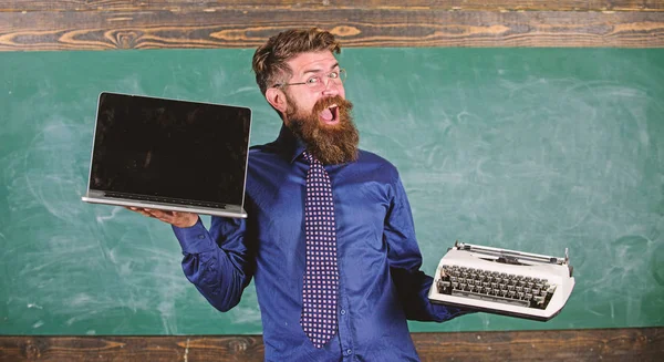 Choose right teaching method. Modern instead outdated. Teacher bearded hipster holds typewriter and laptop. Teacher choosing teaching approach. Digital against retro. Modern technologies benefit