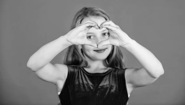 Celebra el día de San Valentín. Amor y simpatía. Concepto de amor. Chica linda niña mostrar gesto de la mano en forma de corazón. Símbolo del amor. Niño adorable chica con el pelo largo sonriente cara mostrar el gesto del corazón a usted — Foto de Stock