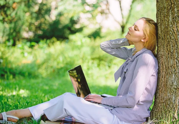 Work outdoors benefits. Woman with laptop work outdoors lean tree. Minute for relax. Education technology and internet concept. Girl work with laptop in park sit on grass. Natural environment office