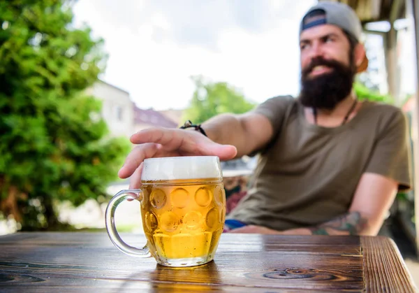 Ele tem o mau hábito de beber muita cerveja. Caneca de cerveja gelada na mesa. Homem barbudo a beber cerveja no bar. Homem brutal relaxa bebendo álcool no restaurante de cerveja. Hipster gosta de beber festa no pub — Fotografia de Stock