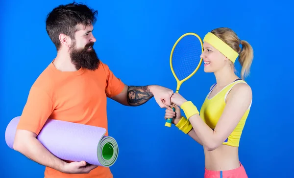 Strong muscles and body. Happy woman and bearded man workout in gym. Sporty couple training with fitness mat and tennis racket. Sport is best motivation. Athletic Success. Strength and motivation