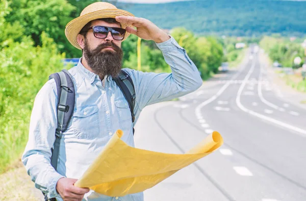 Any transport. Traveler with map looking for hitchhiking transportation alone at edge of road. Tips to get on road. Must know tricks hitchhiking across country. Hitchhiking great way to travel cheap