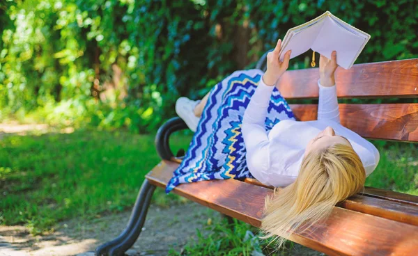 Tiempo para la auto-mejora. La mujer pasa el ocio con el libro. A la señora le gusta leer. Chica leyendo al aire libre mientras se relaja en el banco. Chica laico banco parque relajante con libro, fondo verde naturaleza —  Fotos de Stock