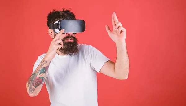 Homem com barba em óculos VR atirando, fundo vermelho. Conceito de galeria de tiro virtual. Cara com cabeça montada tiro exibição com arma na realidade virtual. Hipster em face movimentada jogar em realidade virtual — Fotografia de Stock