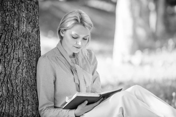 베스트 셀러 상위 목록입니다. 모든 여 자가 읽어야 하는 책. 휴식 레저 취미 개념. 최고의 자기 여성을 위한도 서를 데 도움이. 여자 집중된 앉아 공원 마른 나무 줄기는 책을 읽었다. 영감을 책 읽기 — 스톡 사진