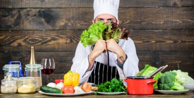 Diyet kavramı. Giyim hat Man ve önlük marul tutun. Sakallı hippi profesyonel şef marul yeşillik tutun. Sağlıklı vejeteryan tarifi. Sağlıklı beslenme. Sağlıklı yemek tarifi. Sağlıklı yemek