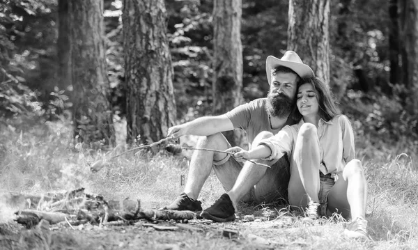 Escursione pic-nic tradizionale cibo arrosto. Hipster e salsicce arrosto ragazza. Coppia preparare salsicce arrosto spuntino natura sfondo. Campeggio e pic-nic. Coppia innamorata campeggio foresta arrosto salsiccia — Foto Stock