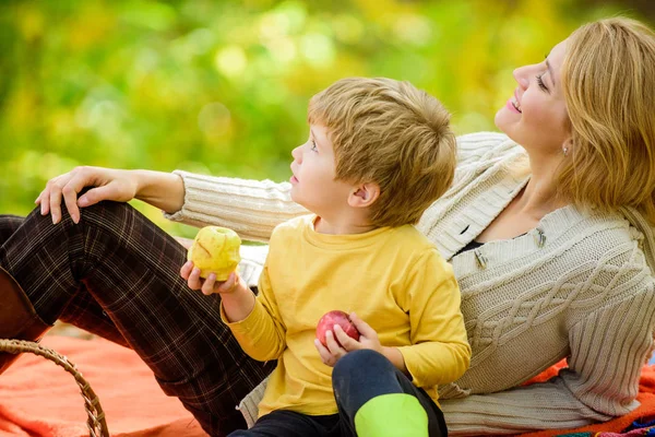 Enjoying spring holiday. Mother love her small boy child. Happy son with mother relax in autumn forest. Sunny weather. Healthy food. Spring mood. Happy family day. Family picnic. Mothers day