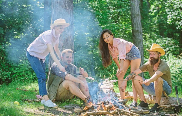 Company friends or family picnic roasting food. Plan for perfect day hike picnic. Friends relaxing near bonfire. Pleasant hike picnic in forest. Friends enjoy picnic eat food nature forest background